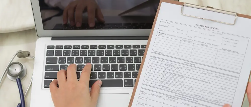 top-view-doctor-using-laptop-clipboard-scaled