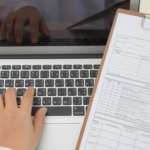 top-view-doctor-using-laptop-clipboard-scaled
